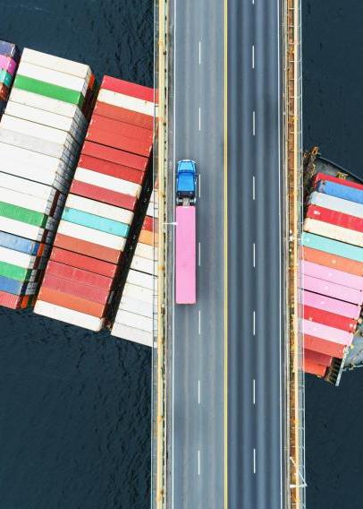 Shipping container sailing under a bridge